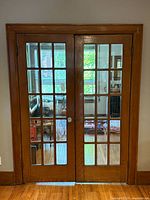 Front view of both French doors installed in frame showing glass panes and wood finish