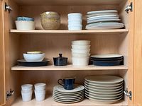 Cabinet shelves showing full assortment of Denby plates, bowls, creamer, sugar pot, tumblers and ramekins