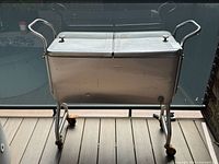 Full view of closed stainless cooler on rolling stand