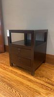 Front view of dark brown Pottery Barn Rhys end table showing open shelf and two drawers