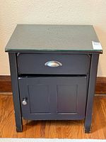 Front view showing drawer, door, glass top, hardware, paint wear