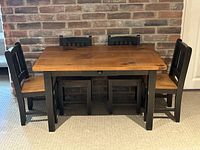 Front view of pine kids table with four chairs against brick wall