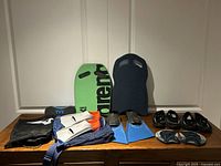 Overall lot showing fins, kickboards, shoes, bags, discs