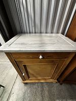 Front view showing marble top, drawer and cabinet door