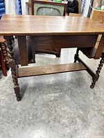 Front and side view of solid oak Jacobean Revival desk with barley twist legs and stretcher shelf