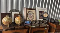 Overall lot showing globes, stone dog bookends, frames, clock, carved wooden shoes