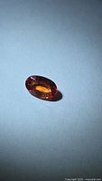 Front view of oval burnt orange sapphire