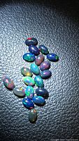 Cluster of oval black opal cabochons showing play of color