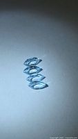 Four marquise‐cut blue gemstones arranged vertically on neutral background