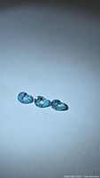 Three pear-cut seafoam blue zircons on light background