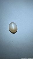 Oval peach moonstone cabochon showing cat’s-eye effect