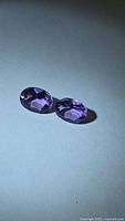 Pair of oval purple amethysts angled view
