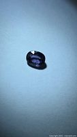 Front view of oval purple spinel showing color and facets