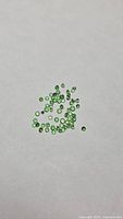 Group of small green round stones on white background