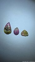 Three carved watermelon tourmaline gemstones on white background