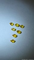 Seven pear-cut yellow sapphires on white background
