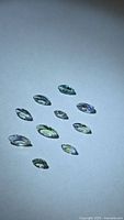 Ten marquise-cut tanzanite gemstones on neutral background