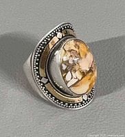 Angled view showing cabochon, gold accents, silver bead trim