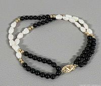 Full view of double strand bracelet showing pearls, black beads, gold spacers and clasp