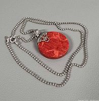 Full view of necklace laid flat showing chain and pendant front