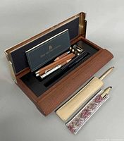 Overall lot showing Faber-Castell case open with contents and two Cross pens in sleeves