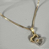 Close view of necklace showing chain and double heart pendant