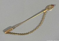 Full view of gold stick pin with chain