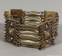 Bracelet standing upright showing articulated panels and link structure