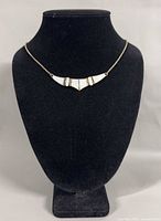 Necklace displayed on stand showing front view with mother of pearl panels