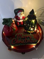 Front view showing entire centerpiece with Santa, tree, gift sack, raised lettering and lights