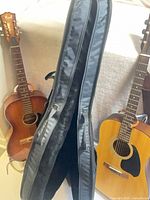 Two acoustic guitars and open soft case