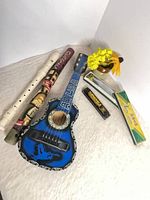 Group shot of recorder, painted flute, miniature banjo, two harmonicas