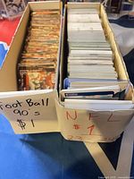 Two full card storage boxes labeled Football 90’s and NFL 23-24