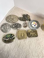 Group shot of nine metal belt buckles on fabric surface