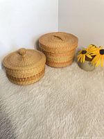 Both woven baskets showing size and lids