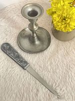 Candlestick and letter opener on surface