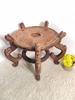 Full view of carved wood plant stand showing top, legs, stretcher