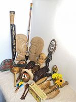 group shot of entire lot showing masks, spears, maracas, paddles and figurines