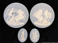 Full set of four plaques on dark background