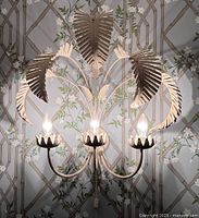 Full view of powder-coated palm frond wall sconce with three lights