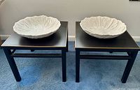 Front view of both tables each topped with white cabbage bowl