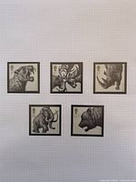 Five Ice Age animal stamps laid out on grid paper