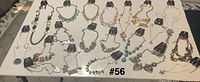 Top view of all 20 necklace and earring sets laid out on table