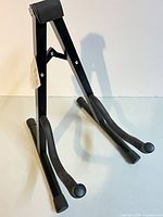 Full view of black folding A-frame guitar stand