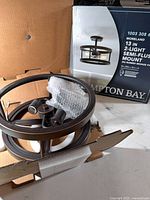 Fixture components and packaging showing Hampton Bay logo