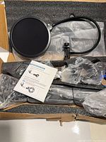 Components in packaging including pop filter, boom arm, clamp