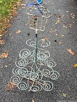 Full view of iron cupcake stand showing scroll tiers and overall wear