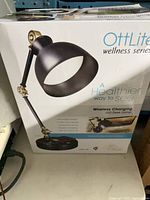 Front of box showing OttLite Wellness Series lamp image and features