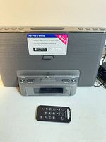 Front view of Sony dock showing speaker grille, Lightning tray and remote