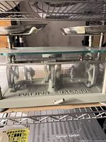 Overall view of torsion balance scale showing glass case, weighing pans, and internal mechanism